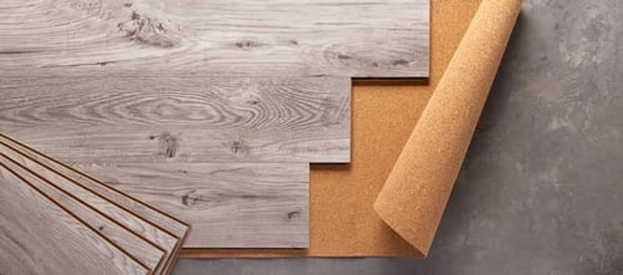 Luxury vinyl plank flooring samples with underlayment laid on a concrete surface
