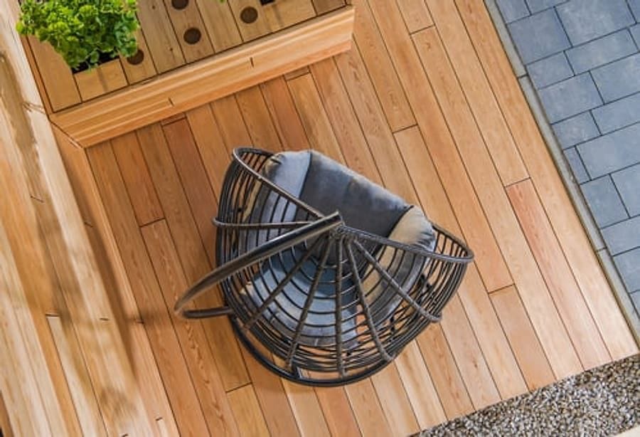Overhead view of a warm wood deck with built-in planter and outdoor seating