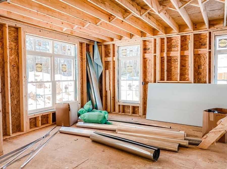 Interior wood framing with window openings and drywall staged for installation